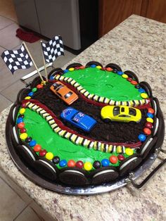 a birthday cake with cars on it sitting on a counter