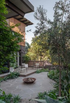 an outdoor patio with chairs and trees in the background