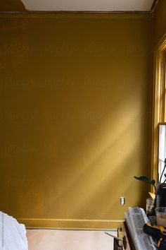 Process photo of room being painted a deep ochre yellow