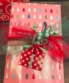 a present wrapped in red and green paper with a tag on it's side