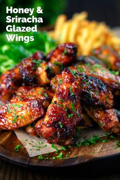 honey and sriraca glazed wings on a plate with french fries in the background