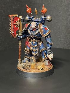 a blue and red painted warhammer with two spears on it's back legs