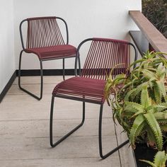 two chairs sitting next to each other on a balcony