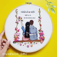 a hand embroidered picture of two people sitting on a swing