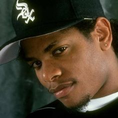 a close up of a person wearing a baseball cap and looking at the camera with a serious look on his face