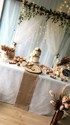 a table topped with lots of cakes and cupcakes on top of a wooden floor