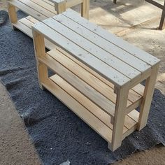 two wooden benches sitting next to each other on top of a blue rug covered ground