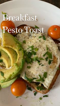 an avocado, tomato and bread on a plate with the words breakfast pesto toast