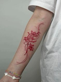 a woman's arm with red ink on it, and flowers in the middle