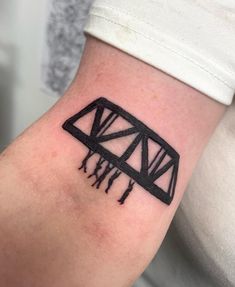 a black and white photo of a bridge tattoo on the arm