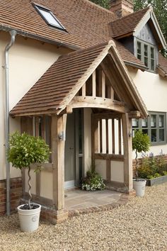 a house with a wooden front door and windows on the side of it's building