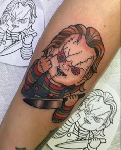 a tattoo on the leg of a woman with a knife and clown face in it