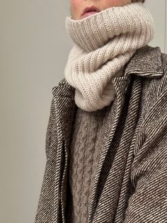 a woman wearing a turtle neck sweater and scarf