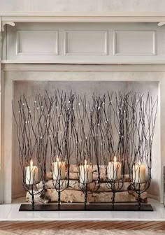 candles are lined up in front of a fireplace with branches on it and the words pint written above them