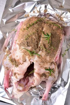 a whole chicken on foil with herbs and seasoning