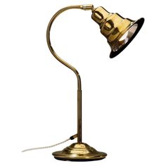 an antique brass desk lamp on a white background