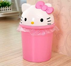 a hello kitty trash can with a pink bow on it's head sitting next to a wall