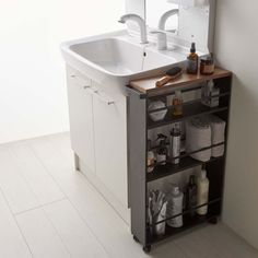 a bathroom sink sitting under a mirror next to a cabinet with lots of items on it