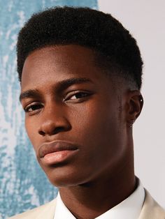 a young man in a suit and tie looking at the camera with an intense look on his face