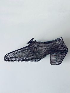 a wire bird feeder sitting on top of a snow covered ground