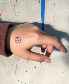 a person's hand with a small tattoo on it