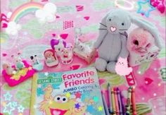 a table topped with toys and books on top of a pink blanket covered in stars