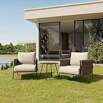 two chairs and a table sitting on the grass in front of a house with sliding glass doors