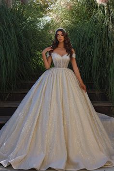 a woman in a ball gown posing for the camera with her hands on her hips