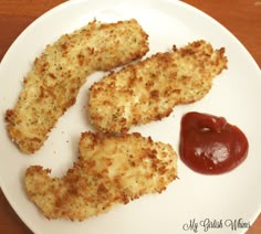 three pieces of fried chicken on a plate with ketchup