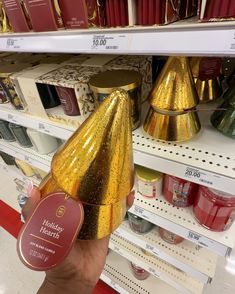 a hand holding a gold party hat in a store