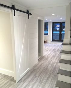 an empty room with white doors and wood flooring on the walls is seen on instagram