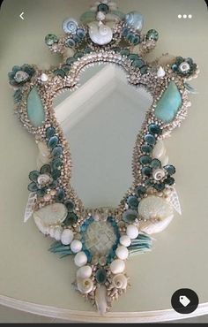 a mirror that has shells and other things on it in the shape of a frame