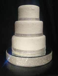 a three tiered wedding cake with white frosting