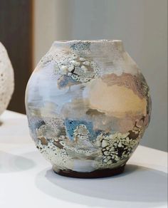 two vases sitting on top of a white table