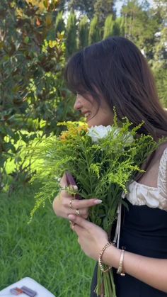 a woman is holding flowers in her hands