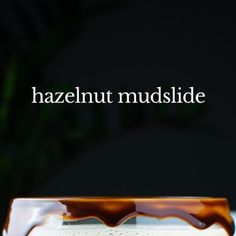 a close up of a cake on a plate with the words hazelnut mudslide