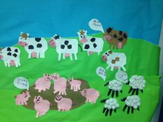 a bulletin board with farm animals and sheep on the grass in front of blue background