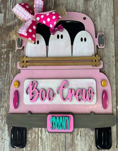 a pink car with two penguins in the back and boo crew on it's license plate