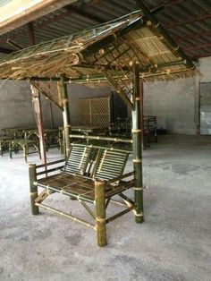 a bamboo bench sitting in the middle of a room with chairs around it and an awning over it