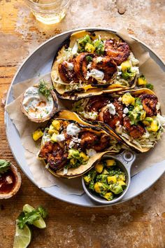 a plate filled with tacos and shrimp on top of a wooden table