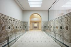 an empty hallway with glass railings and white walls