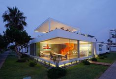 a modern house is lit up at night