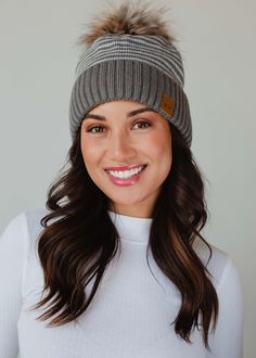 The pom hats EVERYONE loves! Our popular knit pom hats are a must have in your winter closet! You'll reach for this fun winter accessory time and time again this season. Taupe and white striped knit pom hat Natural faux fur pom accent Fleece lined Crown patch on the left side One size Designed in the U.S.A. Produced in China. 100% Acrylic Cold Weather Hats With Pom Poms, Casual Pom Pom Hat For Cold Weather, Pom Hats, Knitted Hats Kids, Knit Hat For Men, Knit Jewelry, Winter Closet, Casual Bottoms, Winter Hats For Women