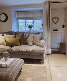 a living room filled with furniture and a clock on the wall