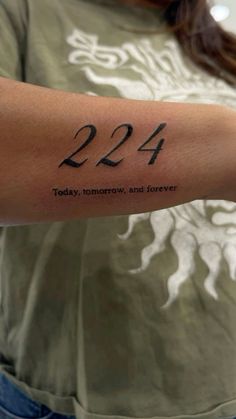 a woman with a tattoo on her arm that reads 223 today, tomorrow and forever