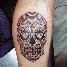 a man with a tattoo on his leg that has a skull and cross in it