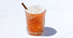 a glass filled with ice and topped with a cinnamon stick