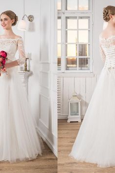 a woman in a white wedding dress standing next to a vase with flowers on it