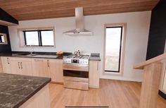 an empty kitchen with wood floors and black counter tops on the walls is seen in this image