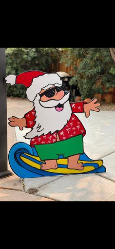 a cardboard cutout of santa claus on a surfboard with sunglasses and a hat